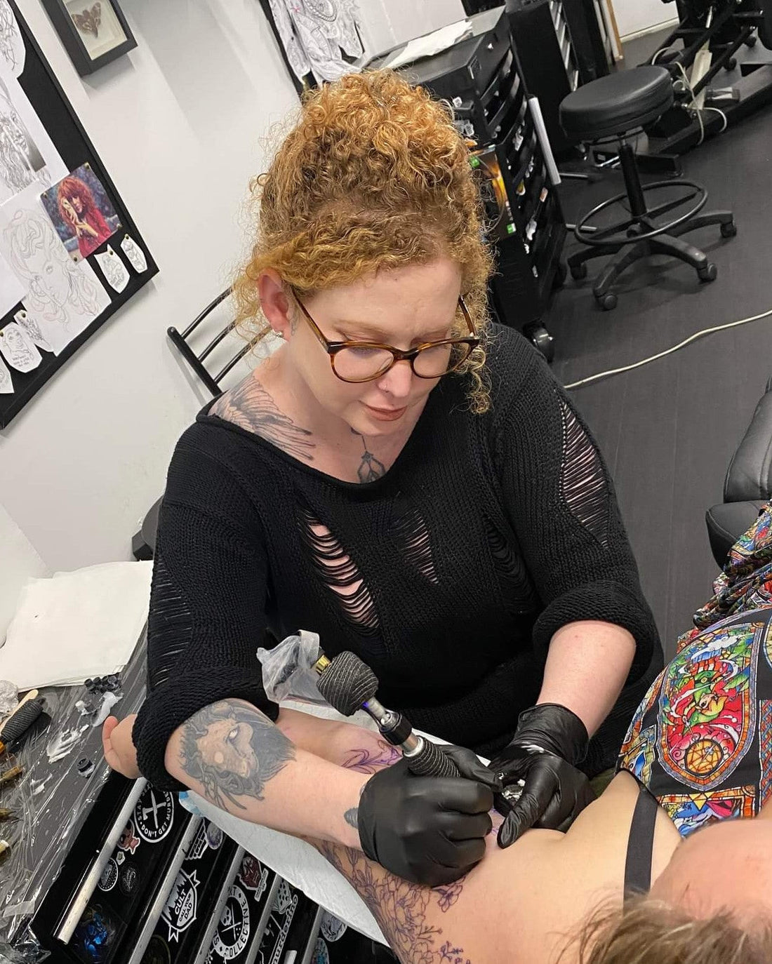 tattoo artist inking woman's arm