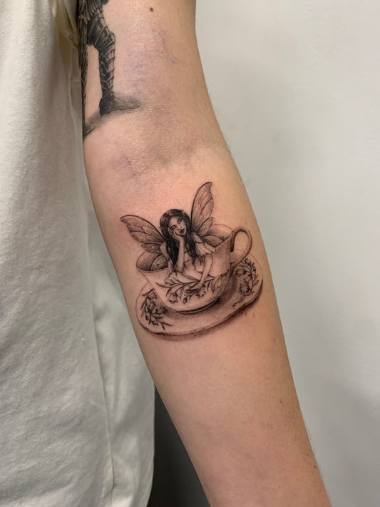 fairy tattoo on persons inner forearm