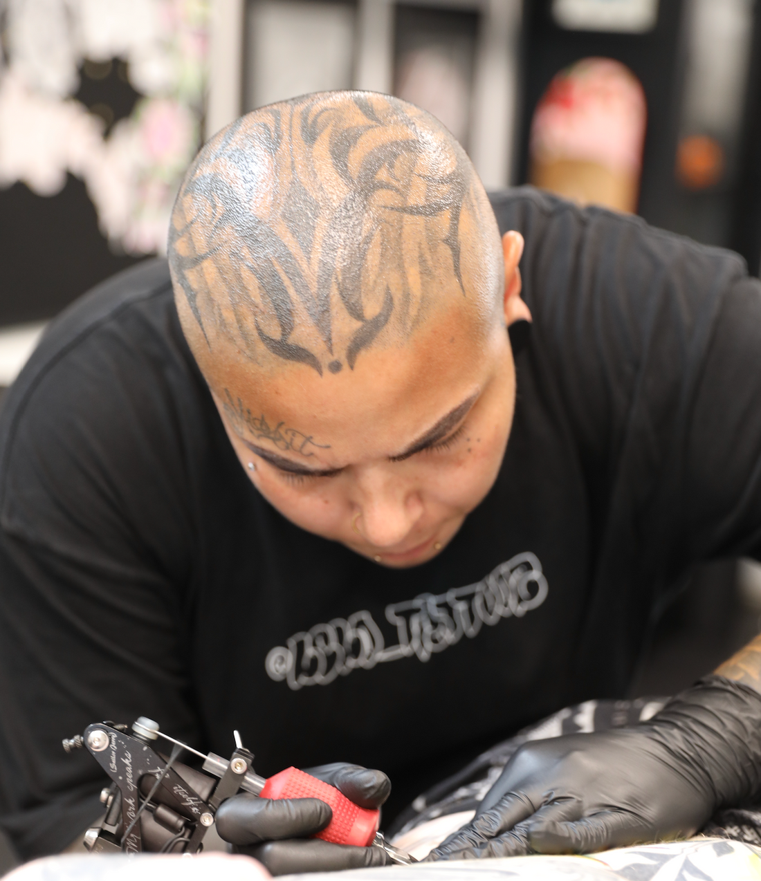 tattoo artist holding tattoo gun inking client