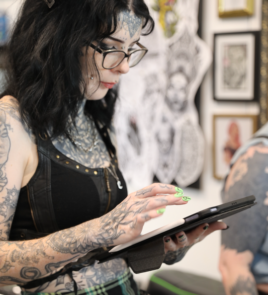 tattoo artist sketching design on ipad